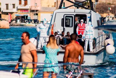 Des migrants mineurs non accompagnés sont escortés depuis le navire « Open-Arms »  jusqu’à Lampedusa, en Italie, le 17 août. ALESSANDRO SERRANO / AFP