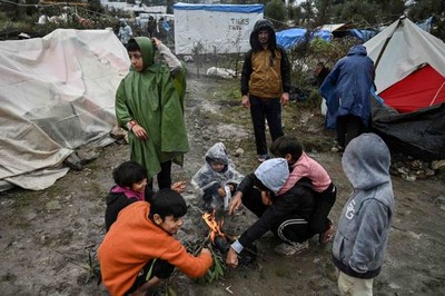 Des enfants autour d’un feu dans le camp de Moria, sur l’île de Lesbos, en Grèce, le 26 novembre 2019. ARIS MESSINIS / AFP