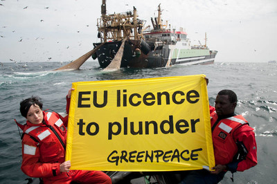Melanie Aldrian (from Greenpeace Austria) and Philippe Ahodekon, a Greenpeace volunteer from Senegal, hold a banner in front the Dutch flagged super trawler “Dirk Diederik”, fishing in Mauritanian waters. 