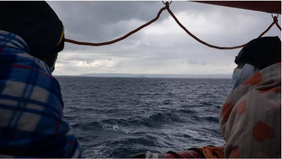 Deux migrants regardent la mer sur le bateau Ocean Viking, affreté par l ONG SOS Mediterranee, le 23 mars 2021 (JEREMIE LUSSEAU / HANS LUCAS / AFP)