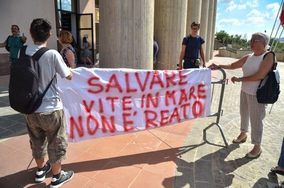 Des manifestants brandissent une banderole devant le tribunal d’Agrigente (Italie). Il y est inscrit « sauver des vies en mer n’est pas un crime ». ANDREAS SOLARO / AFP