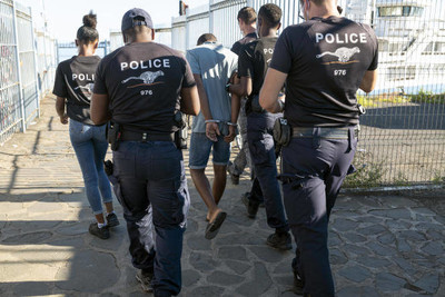 Des membres du Groupe d’appui opérationnel de la police aux frontières escortent un homme n’ayant pas de papiers, à Mayotte, le 26 mars 2021. WILLIAM DANIELS POUR « LE MONDE »