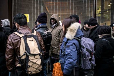 Devant la préfecture de Lyon, en 2015, des étrangers résidant en France attendent pour faire renouveler leur titre de séjour. JEFF PACHOUD / AFP