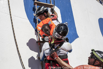 Migrants grimpant l’échelle en fer de l’Aquarius